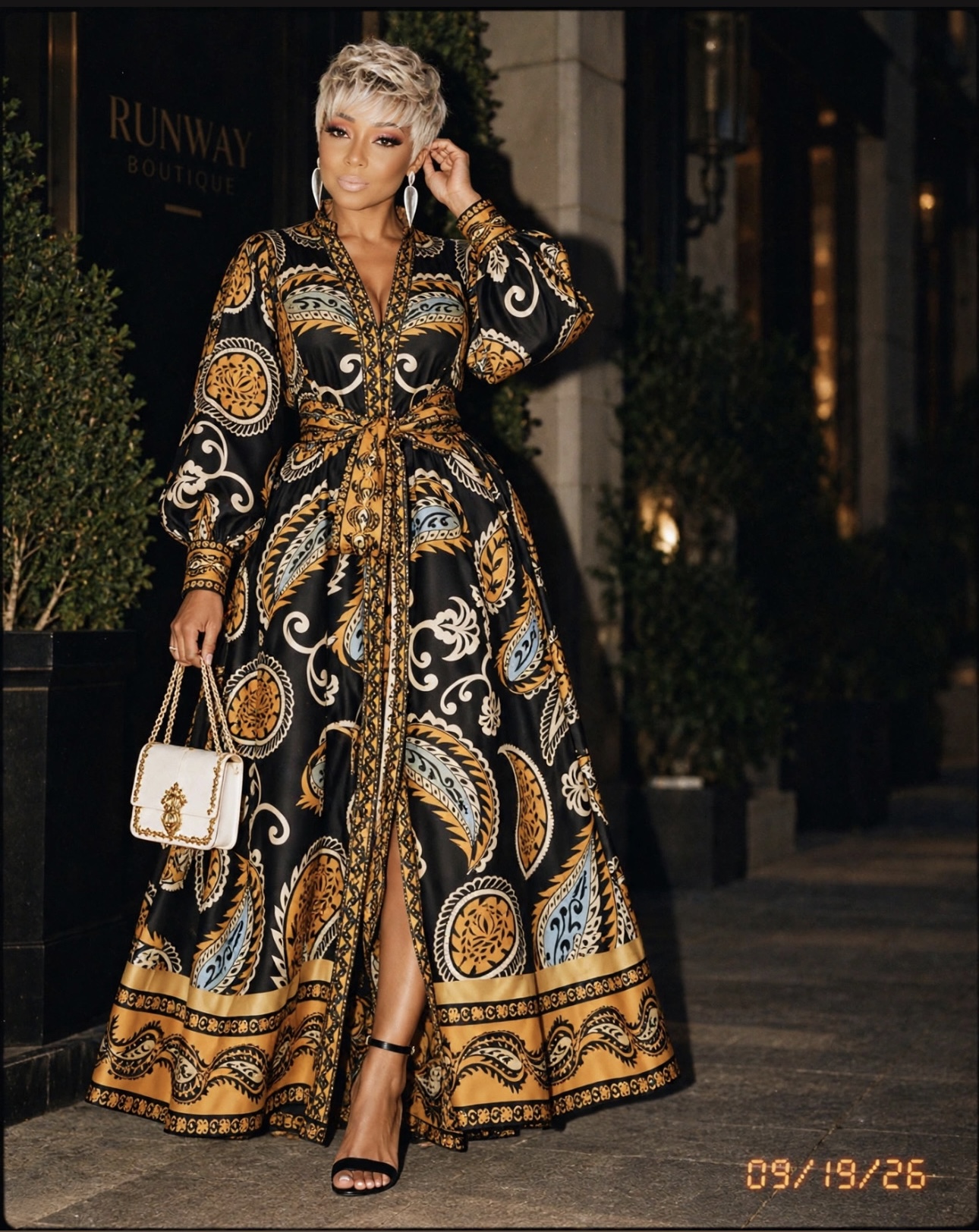 Kimberly in a black and gold patterned maxi dress